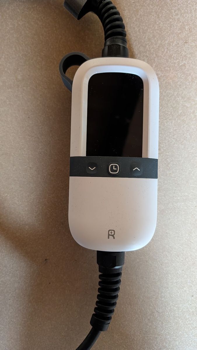 Boîtier de contrôle blanc du chargeur Rheidon PC200-3K6, avec son écran et trois boutons : deux flèches et une horloge